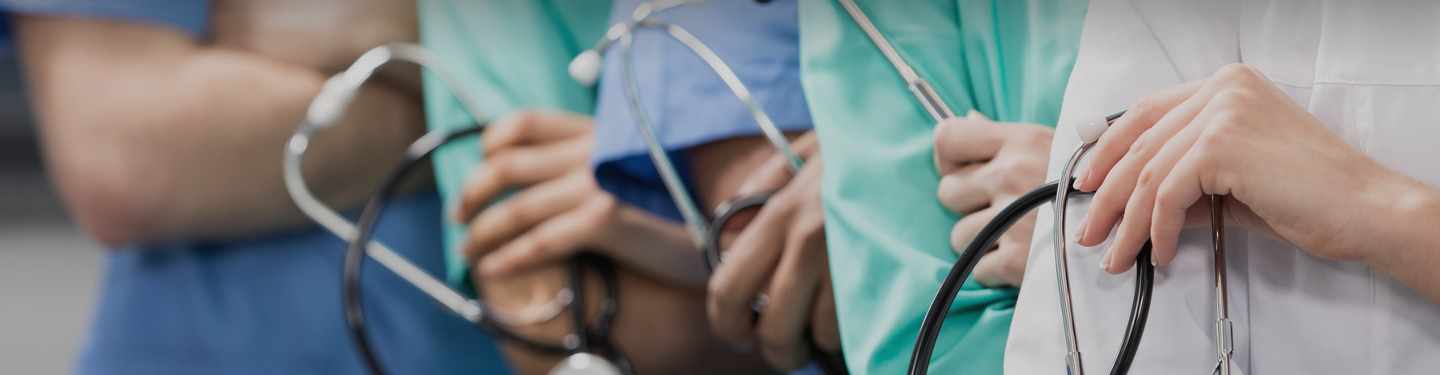 Close up of Doctors arms crossed with stethescopes.