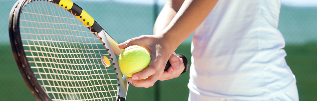 Woman with tennis ball and raquet.
